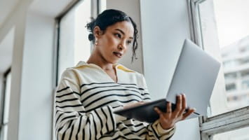 Young woman reading something on her laptop.