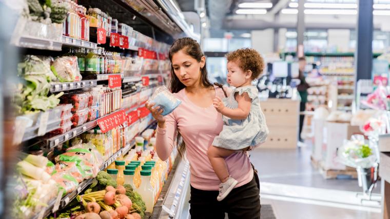 Mother and small child shopping in grocery store.