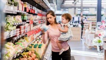 Mother and small child shopping in grocery store.