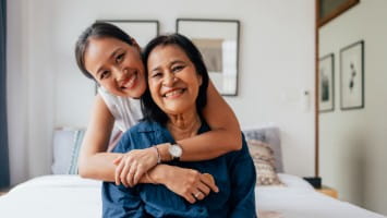 Woman hugs her senior mother.