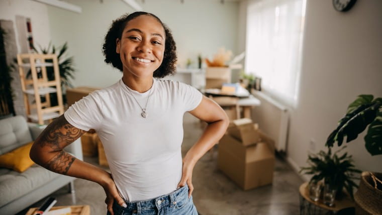 Happy young woman standing in new apartment.