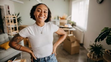 Happy young woman standing in new apartment.