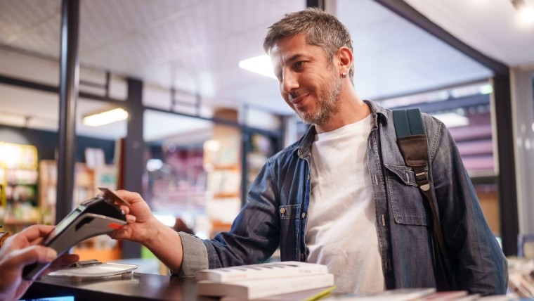 Young man making purchase with credit card.