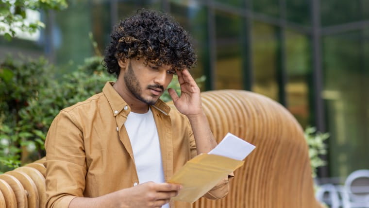 Stunned man reading legal summons.