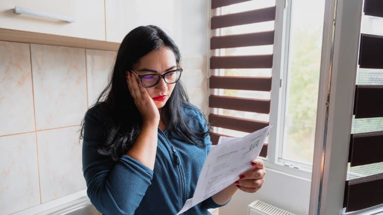 Unhappy woman reading bill.