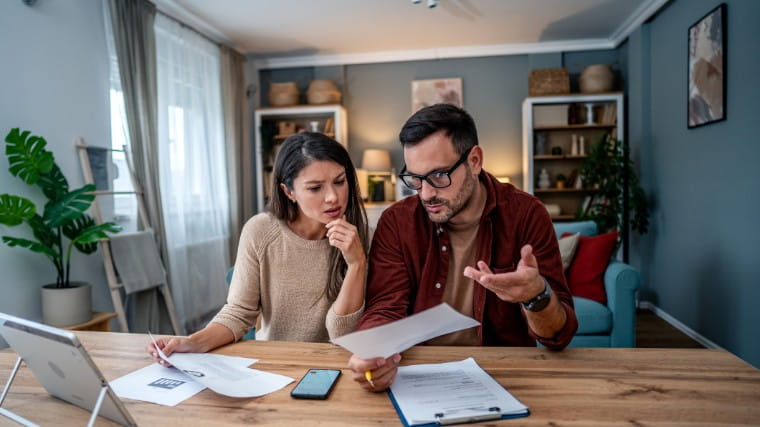 Stressed out couple discussing their finances together.