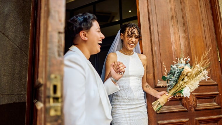 Newly married couple walking through door.