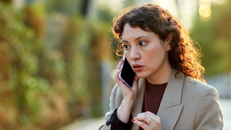 Professional woman looking worried while on phone call.