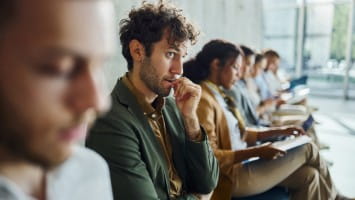 Nervous young man sits while waiting for job interview.