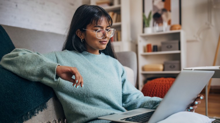 Young woman reading something on her laptop.