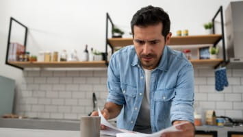Concerned man reading paperwork.
