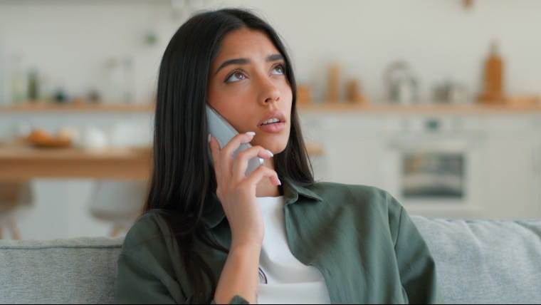 Concerned young woman speaking on phone.