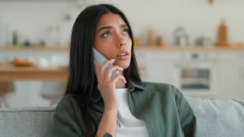 Concerned young woman speaking on phone.
