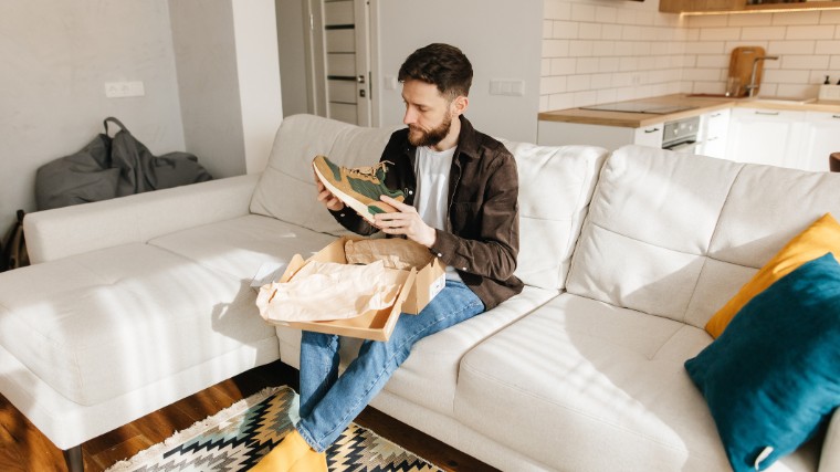 Man opens box of new shoes.