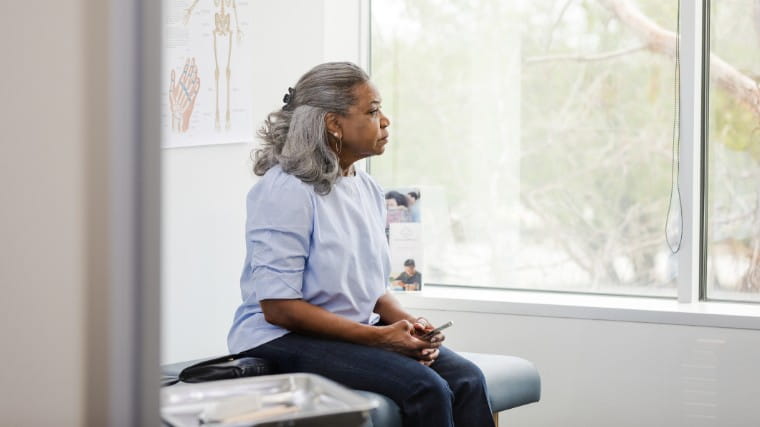 Senior woman waits in doctor's office.