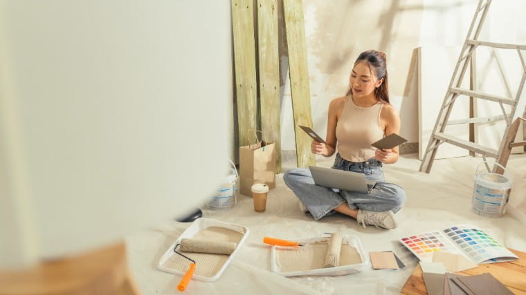 Young woman looking at paint options for house.