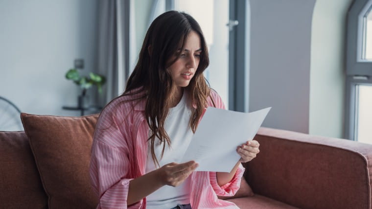 Young woman reading letter.
