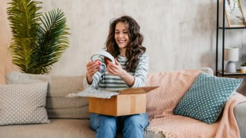 Woman unboxing new pair of headphones.
