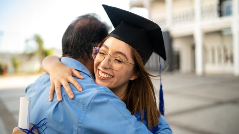 New graduate hugging parent.