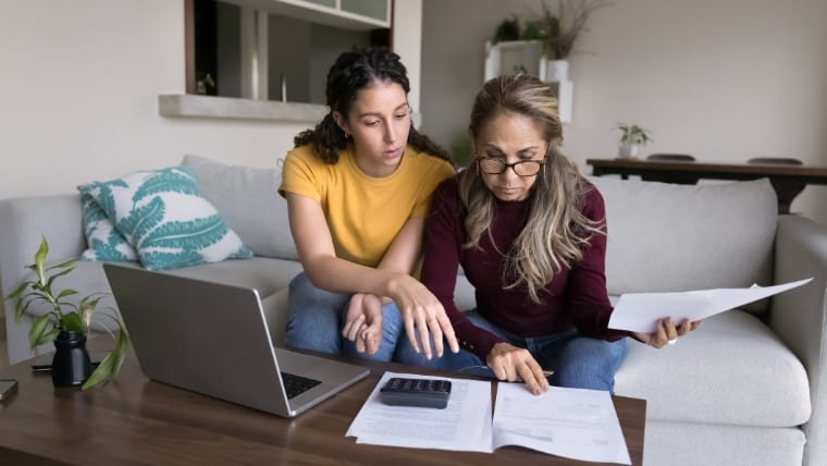 Young woman reviewing paperwork with her mother.