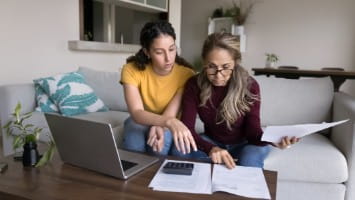 Young woman reviewing paperwork with her mother.