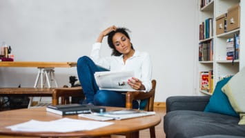 Woman reading newspaper.