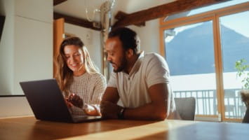 Couple reviewing information on a laptop.