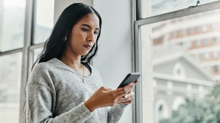 Young woman reading cellphone.