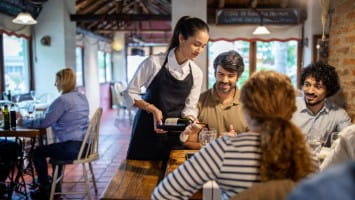 Waitress serving table of customers.