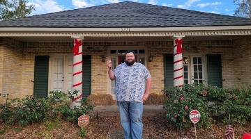 Jason Rabalais in front of his home.