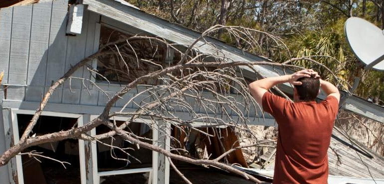man assessing damage to his home