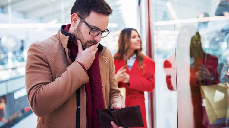 Man looking into his mostly empty wallet