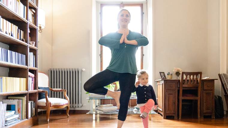 mother and small daughter doing yoga together