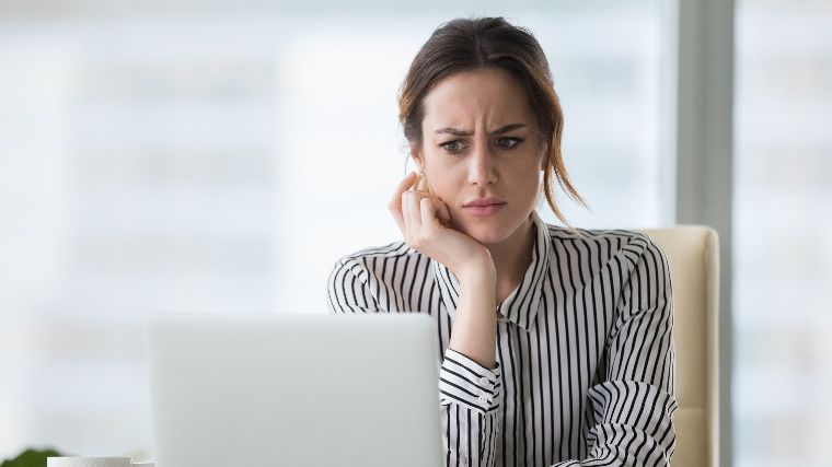 Concerned woman using laptop.