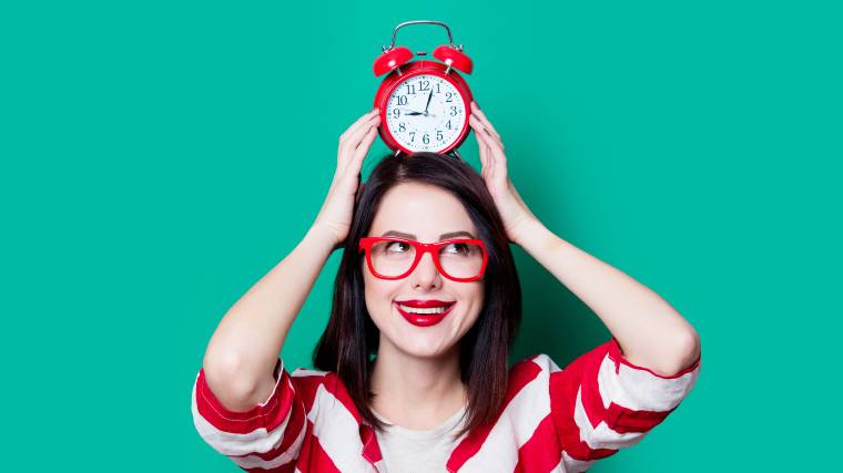 Woman with clock in front of green background