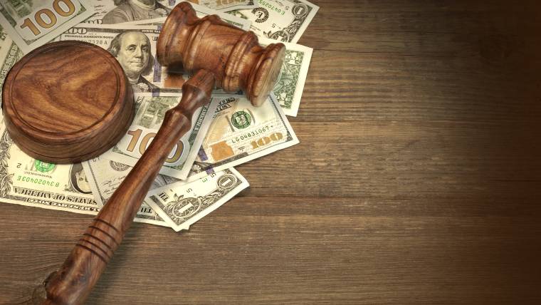 Gavel and money on wood surface