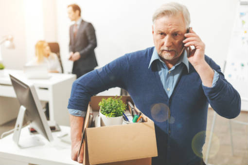 Senior gentlemen leaves job with belongings in a box