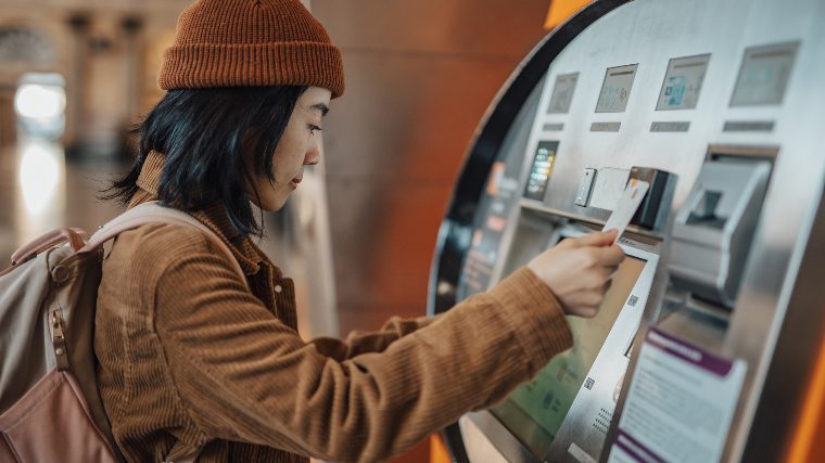 Woman using outdoor ATM.