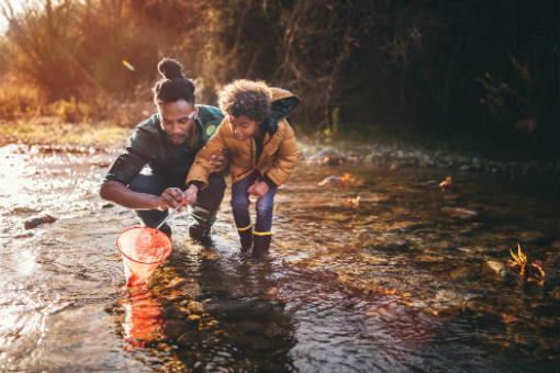 Father and son play in a stream