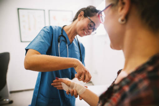 Nurse wrapping hand of patient