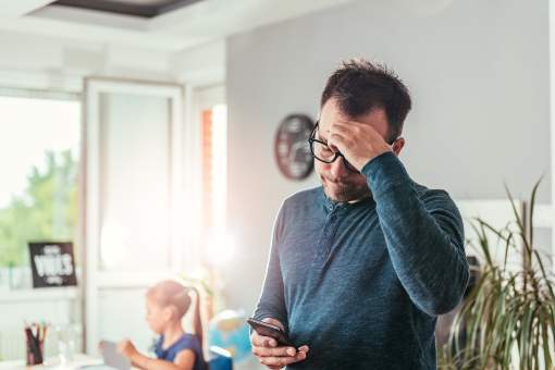 Worried father reading smartphone