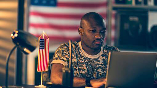 Military servicemember using a laptop