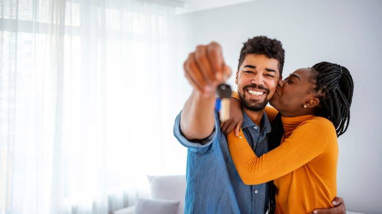 A couple shows off the keys to their new house.