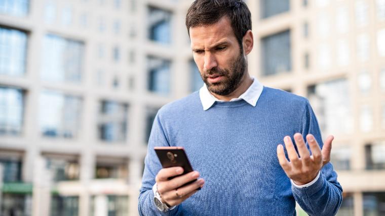 Unhappy man looking at phone.