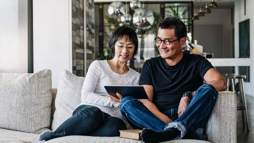 two seniors using a computer tablet on the couch