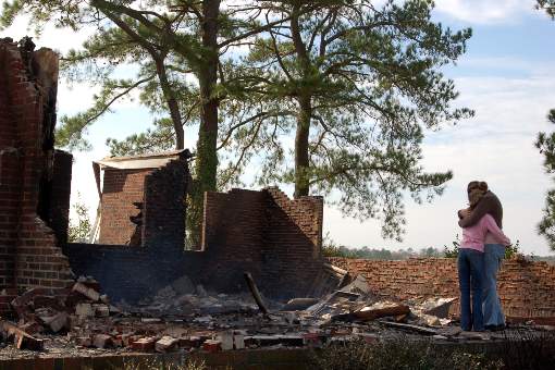 Couple looking at remains of destroyed home