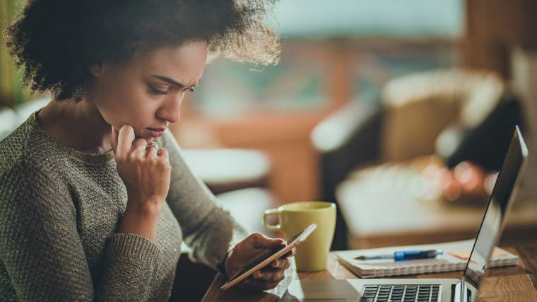 Concerned woman looking at her phone