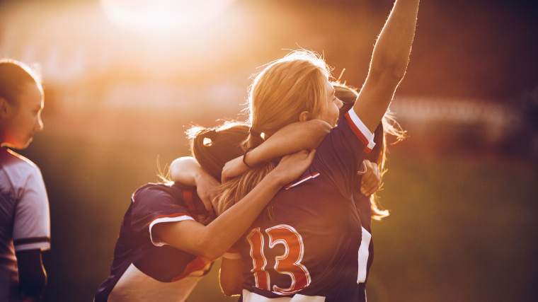 happy athletes celebrating on the field