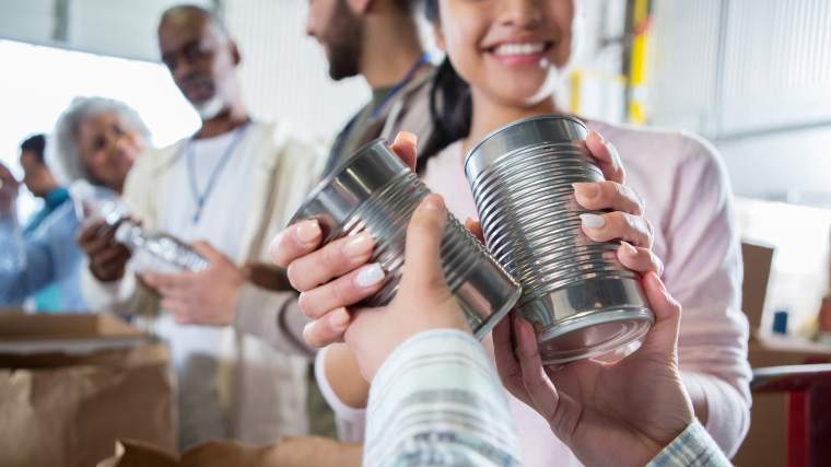 volunteer at food bank provides canned goods