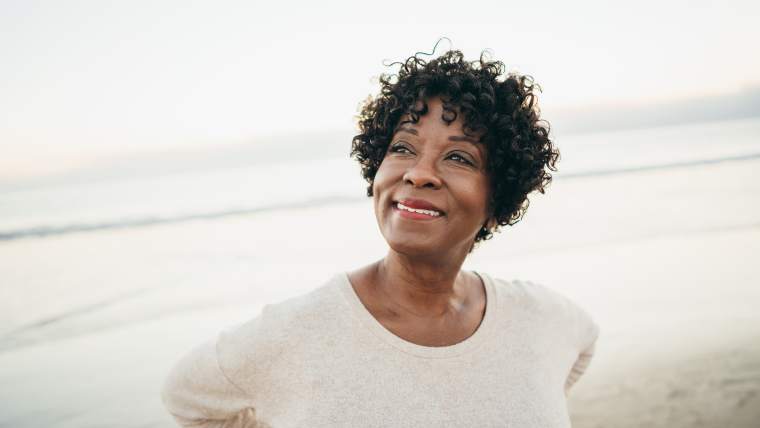 woman nearing retirement age walking on the beach